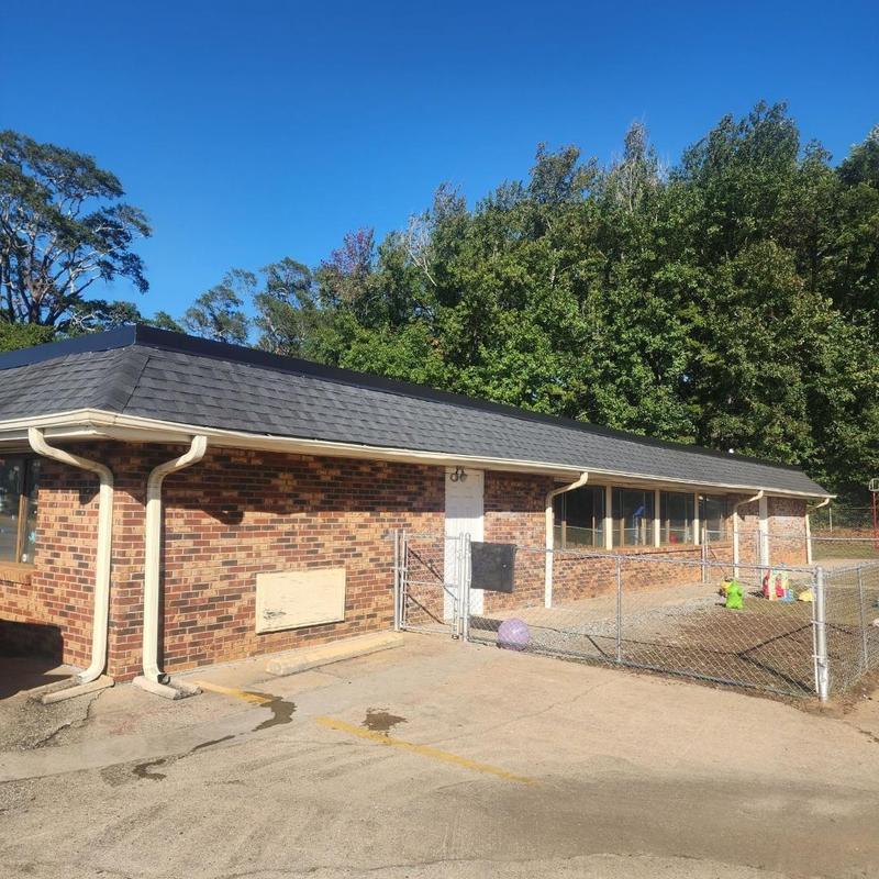 Asphalt shingle roofing on brick building exterior Asphalt shingle roofing on brick building exterior