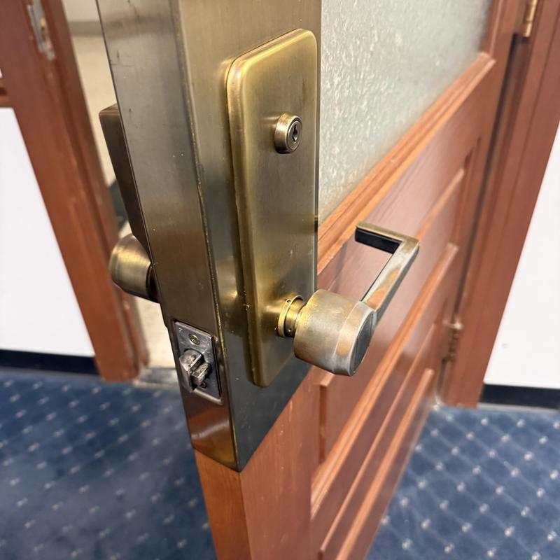 Brass door lockset with lever handle on wooden door
