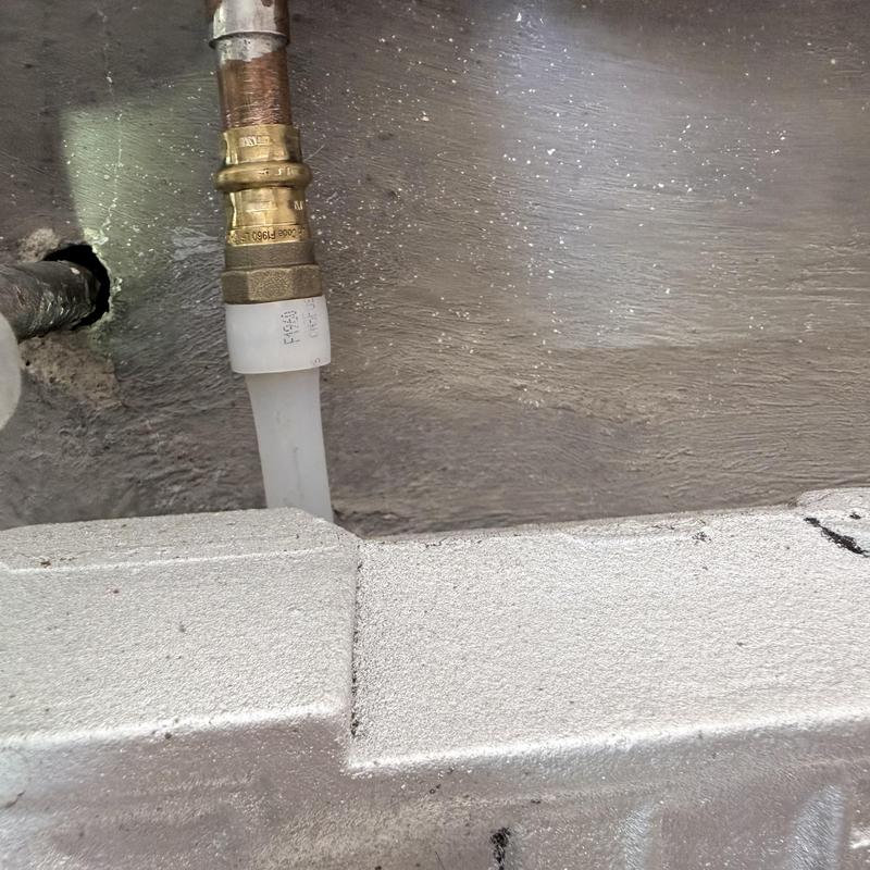 PEX piping connection with brass fitting near wall