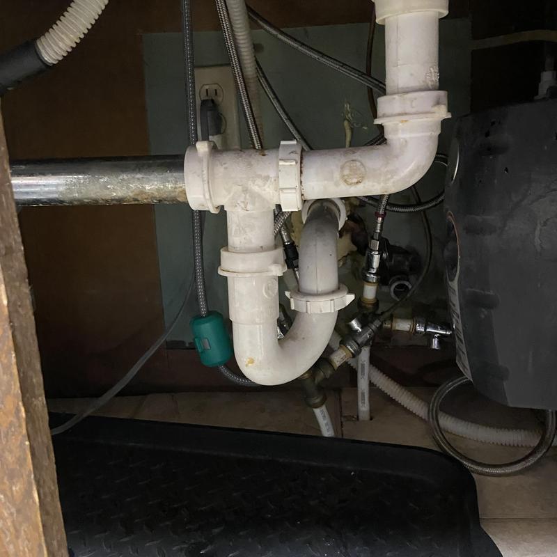 Kitchen sink PVC drain pipes and water lines under cabinet