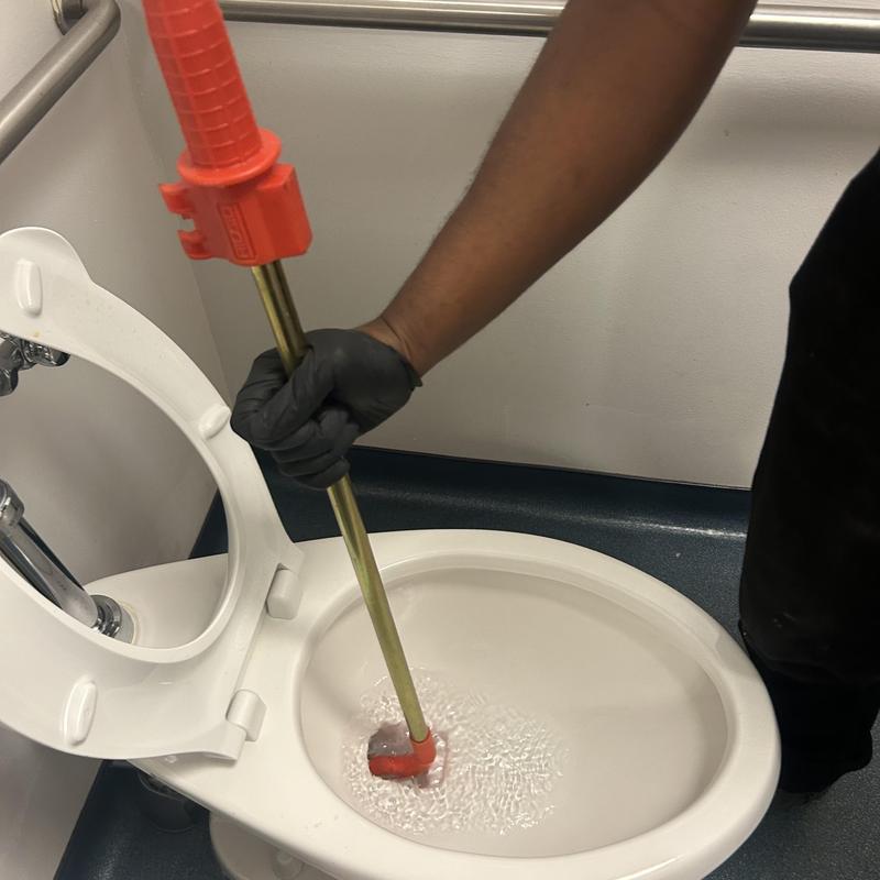 Toilet auger clearing blockage in waiting room toilet Toilet auger clearing blockage in waiting room toilet