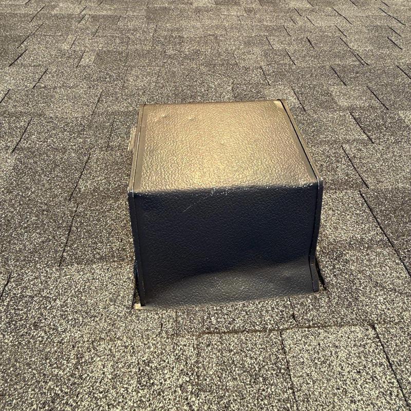 Roof vent flashing with hail damage on asphalt shingles