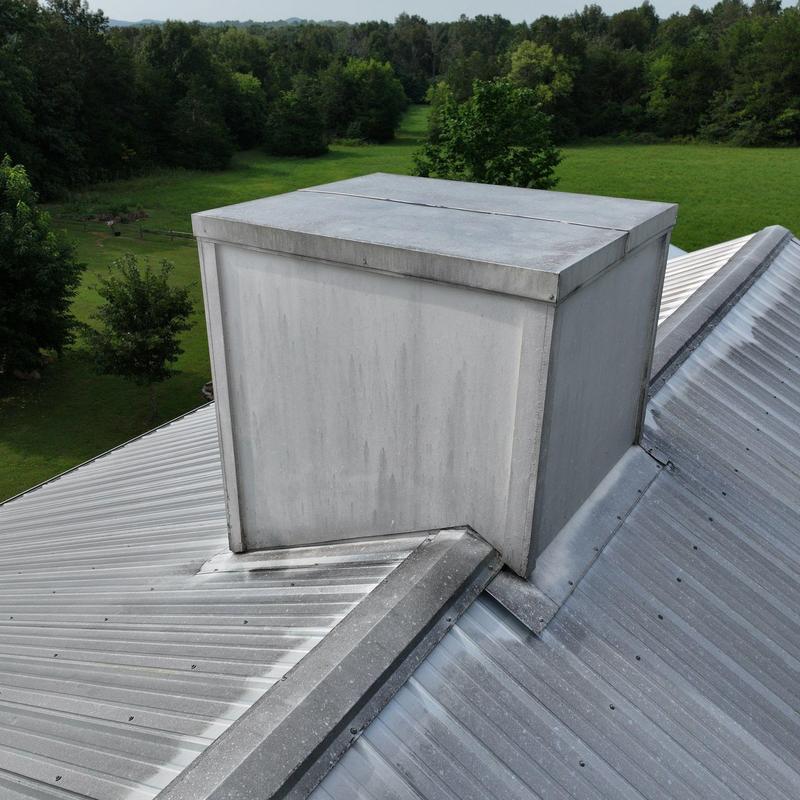 Metal roof chimney flashing and enclosure on rural home