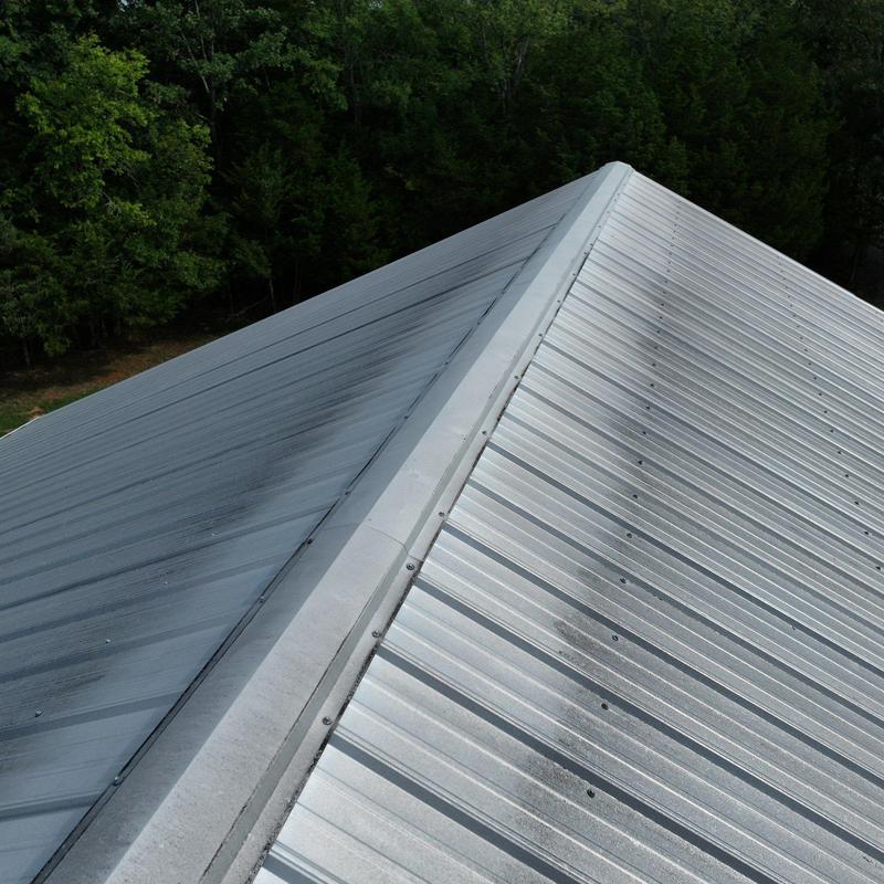 Metal roof panels with ridge cap in forest setting