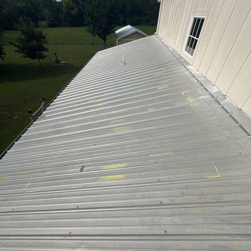 Metal roof with hail damage marked for repair