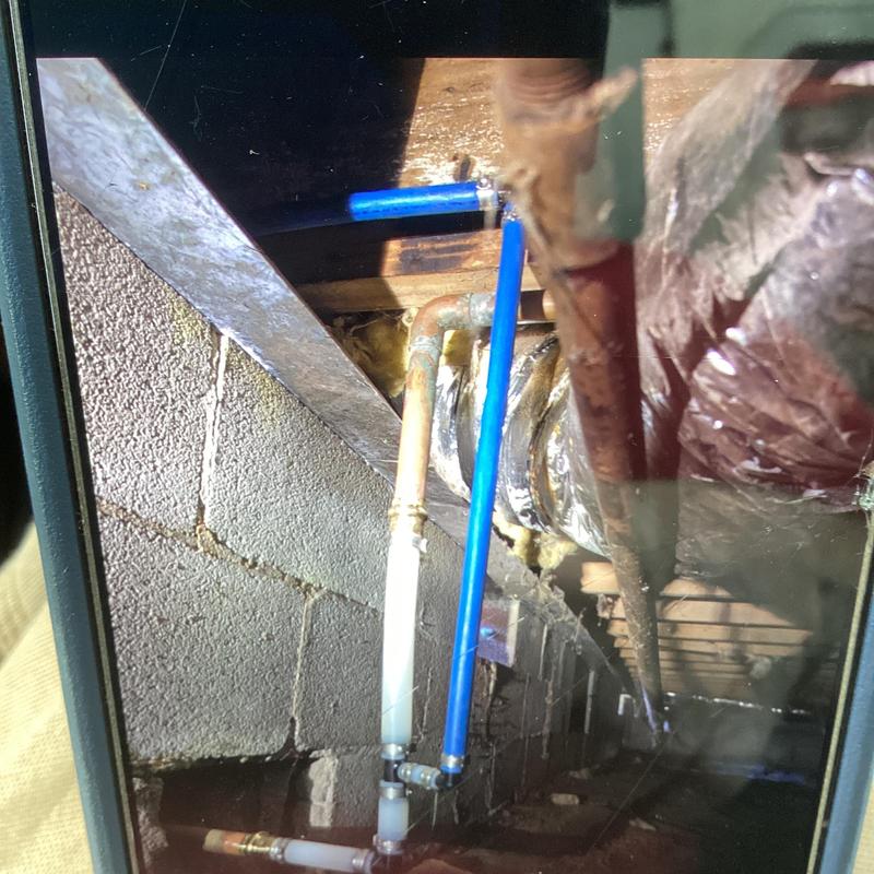Blue PEX pipe reroute in crawl space plumbing system