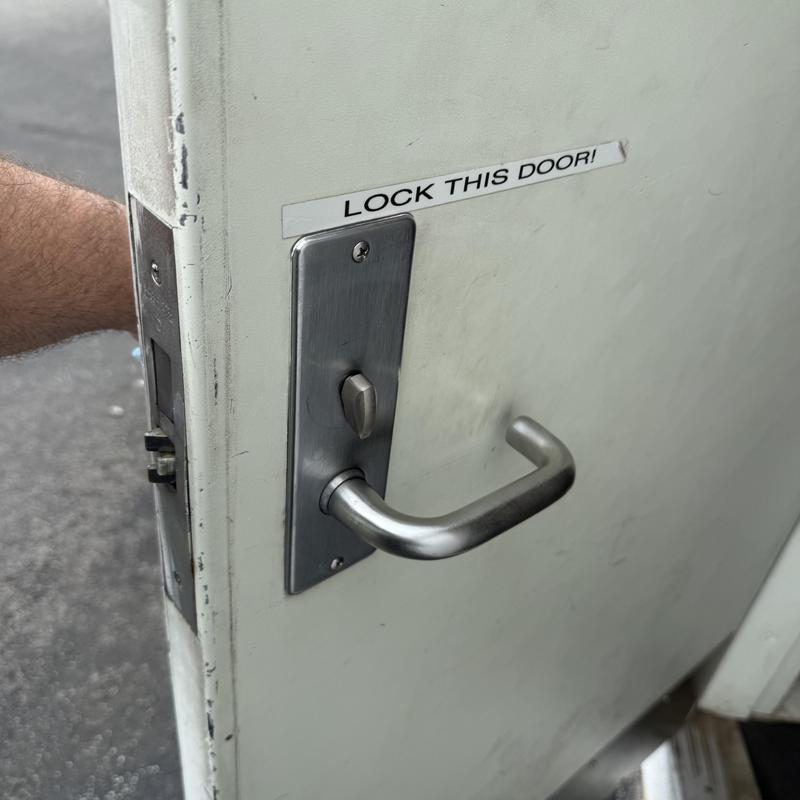 Corbin mortise lock on white delivery door with handle