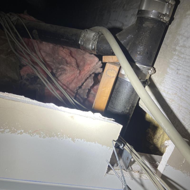 Cast-iron vent pipe with temporary wood bracing in ceiling cavity