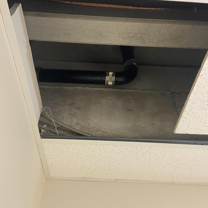 Cast-iron plumbing vent pipe with missing bracing above ceiling tiles