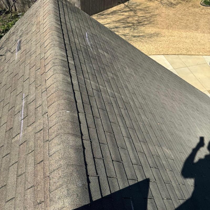 Asphalt shingle roof with manufacturer markings on slope