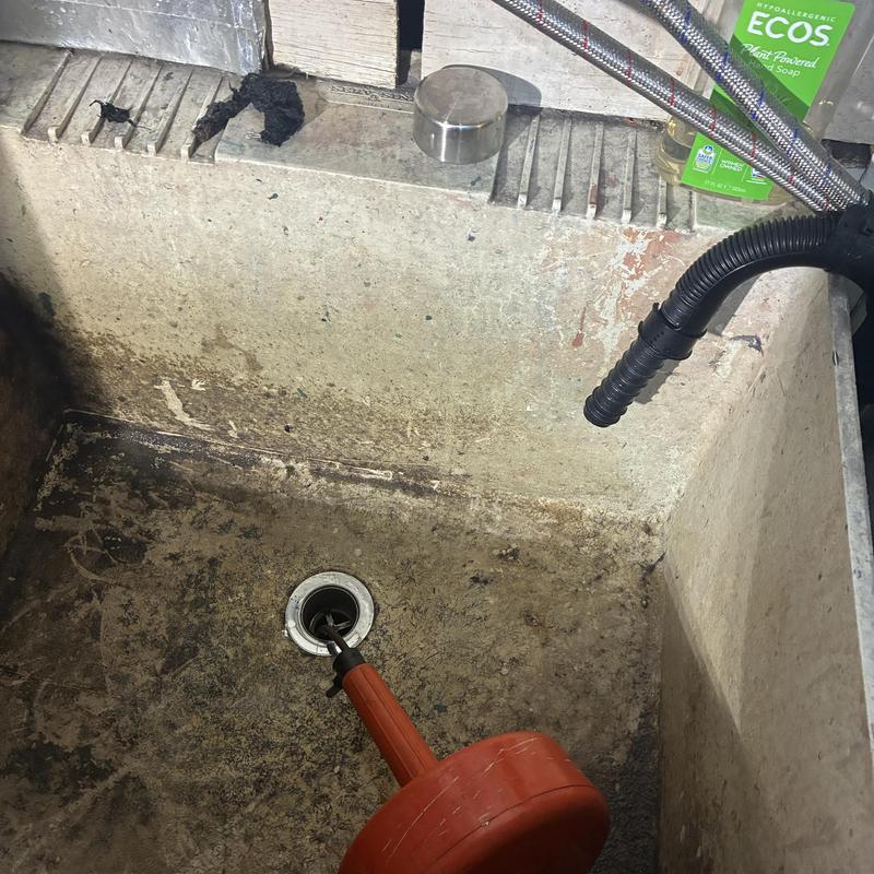 Utility sink drain clearing with plumber's snake tool