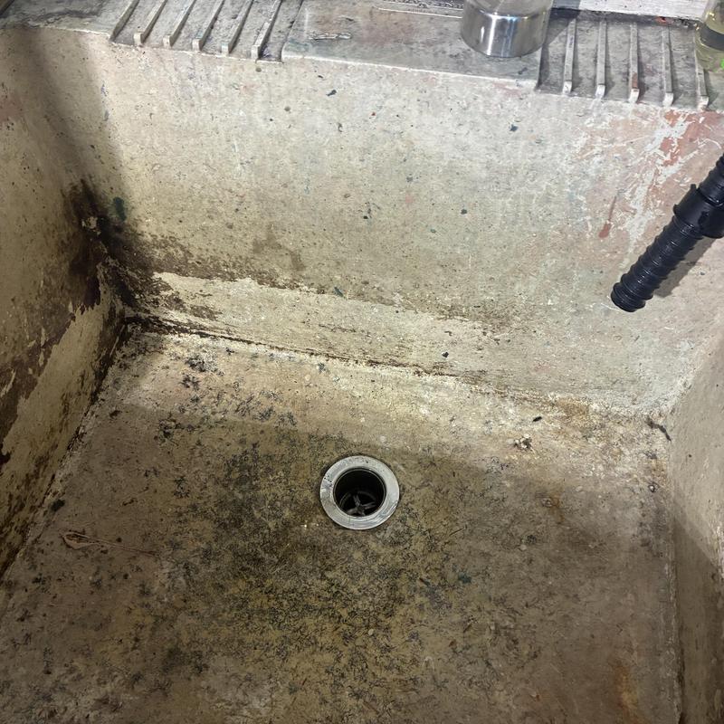 Utility sink drain with debris before cleaning