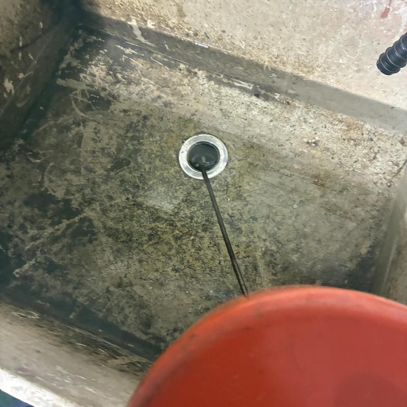 Utility sink drain cleared with plumbing cable