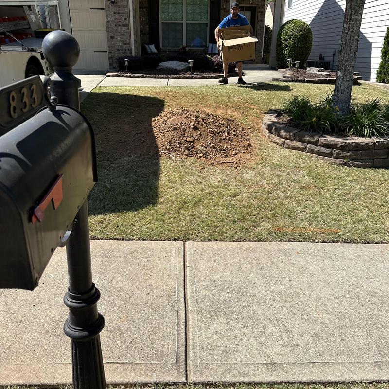 Sewer main cleanout repair with soil mound in yard