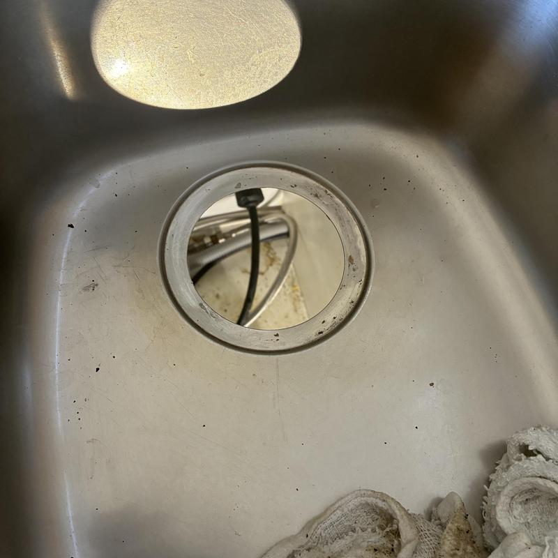 Garbage disposal drain opening in stainless sink basin