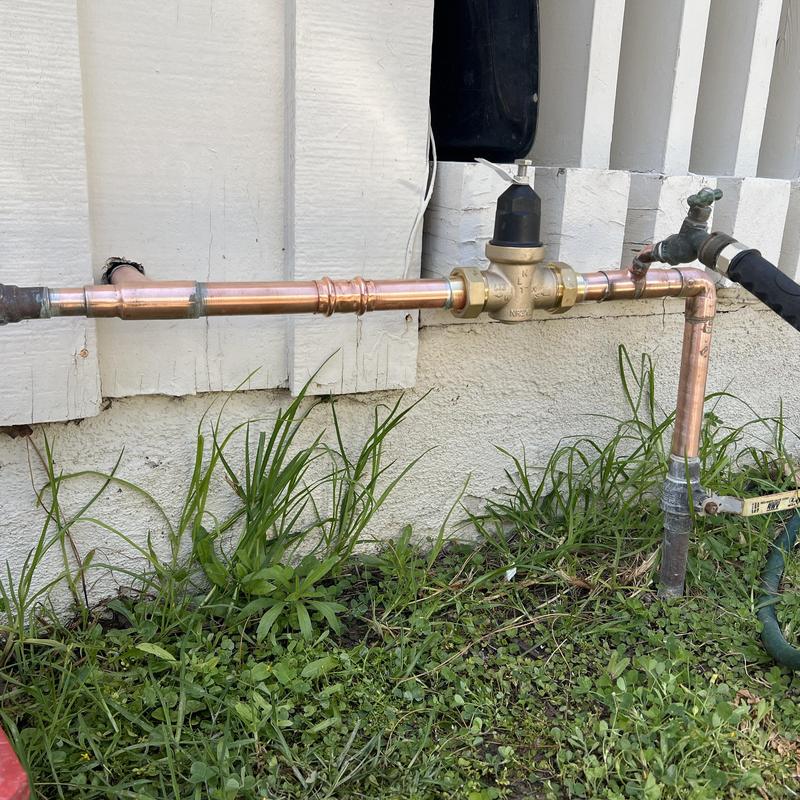 1-inch water pressure regulator with copper piping outdoors 1-inch water pressure regulator with copper piping outdoors