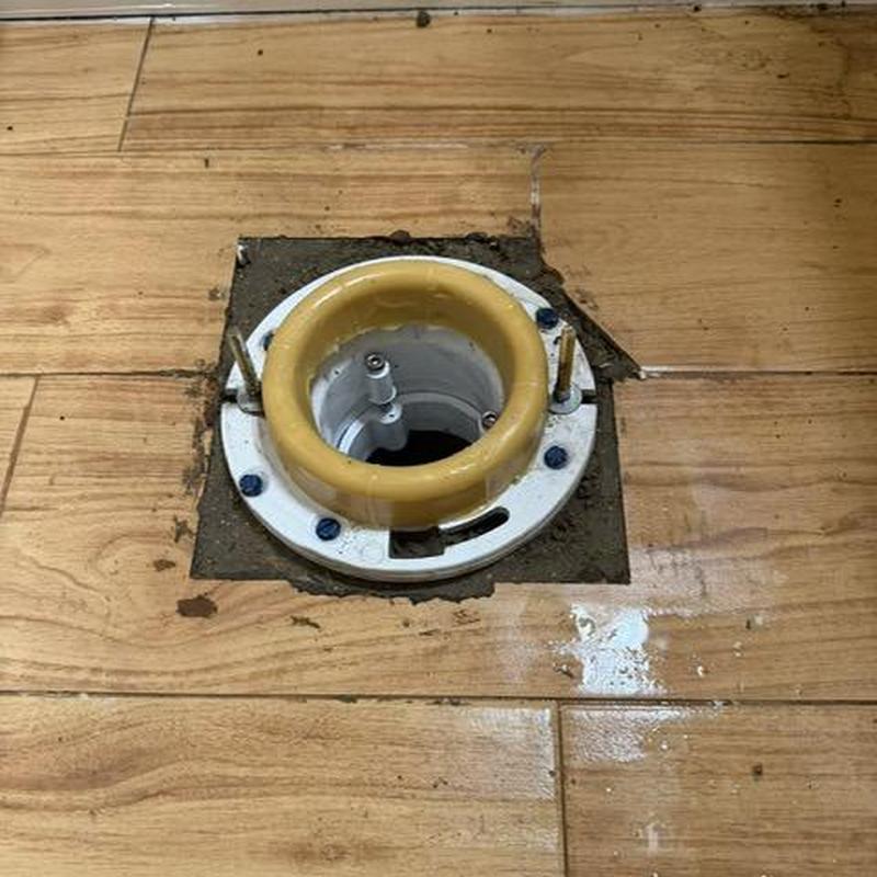 PVC toilet flange installed on wood floor