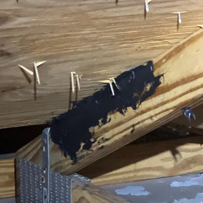 Roof truss wood with black sealant patch inside attic space