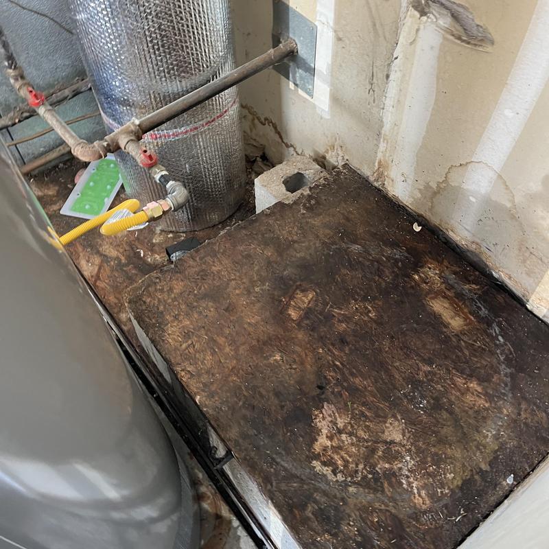 Water heater base with visible water damage and rust stains