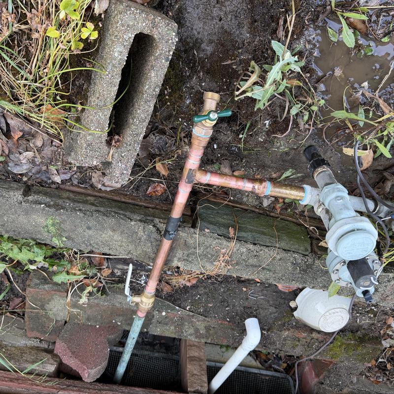 Copper irrigation piping with valves in soil trench