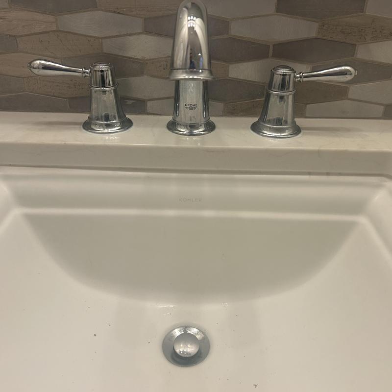 Bathroom faucet with chrome handles and backsplash tiles