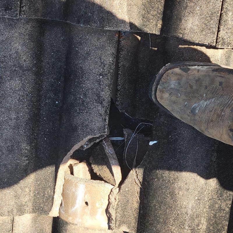 Concrete tile roof with broken and displaced tiles