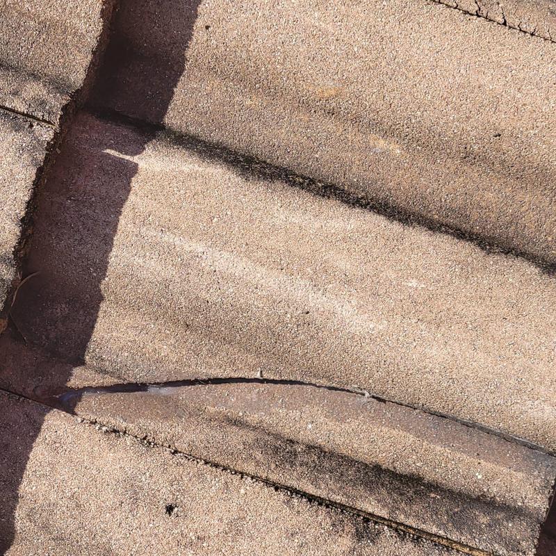 Concrete tile roof with cracked and displaced tiles