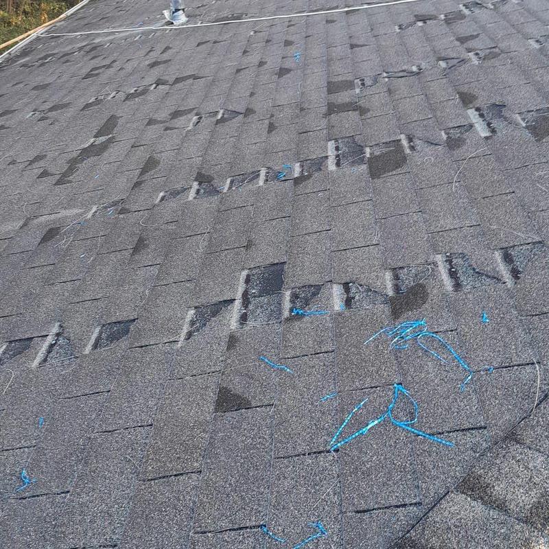 Shingle roof with hail impact damage marked for repair