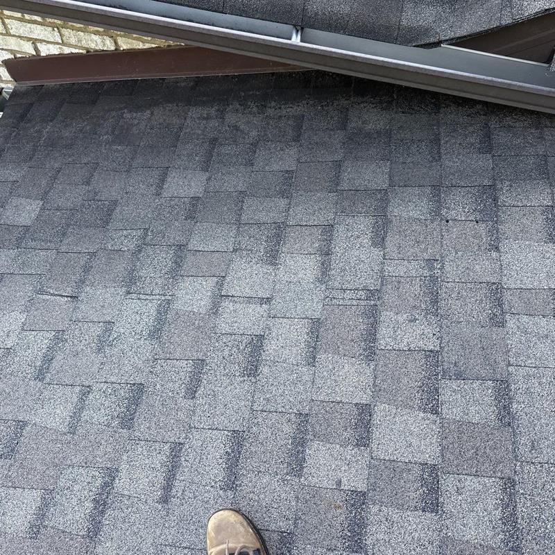 Asphalt shingle roof with hail damage near gutter edge