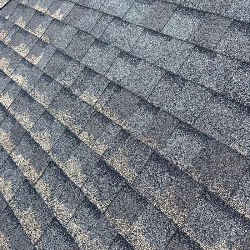 Asphalt roof shingles with hail damage and wear