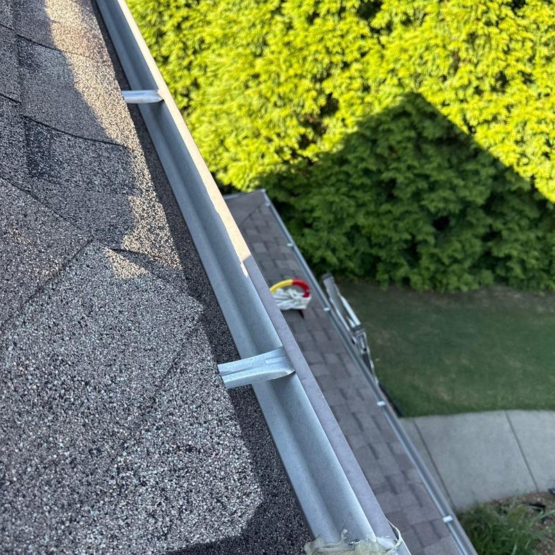 Roof gutter system inspection on asphalt shingle roof