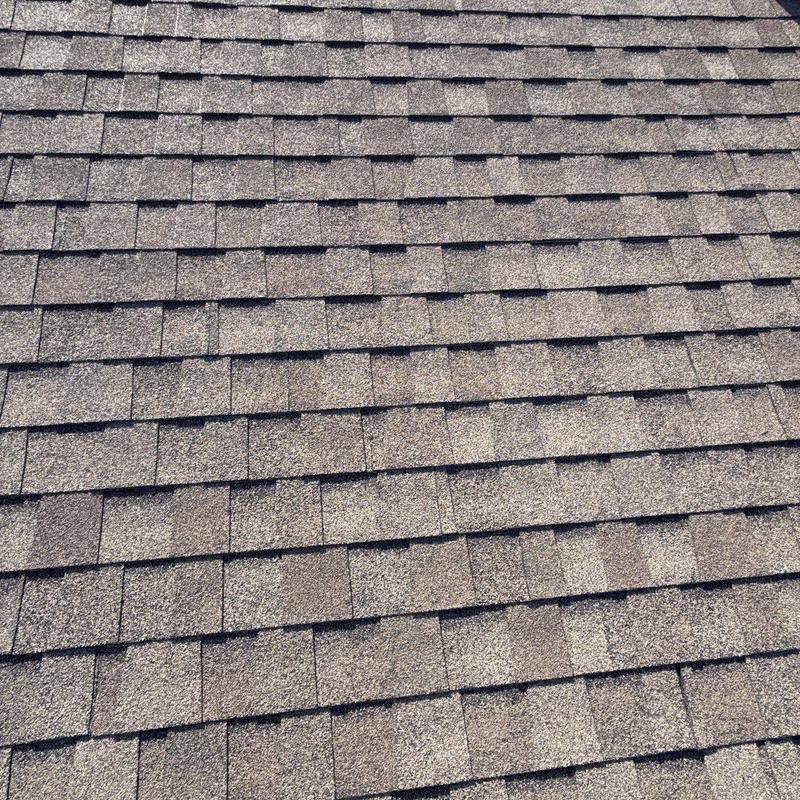 Asphalt roof shingles with visible hail damage close-up
