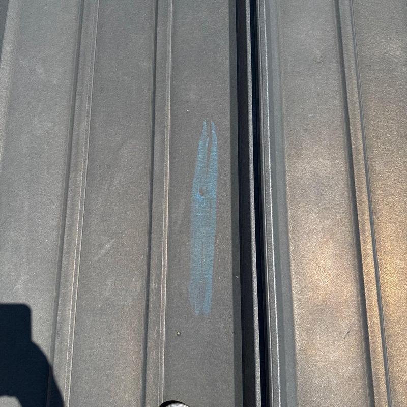 Metal roofing panel with hail damage mark