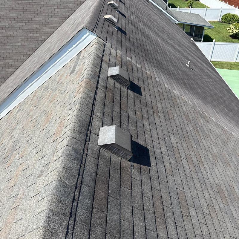 Asphalt roof shingles with vent covers and ridge caps