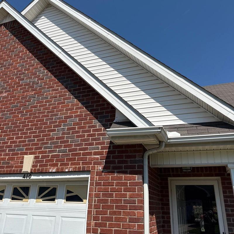 Roof siding and gutter systems on brick house exterior