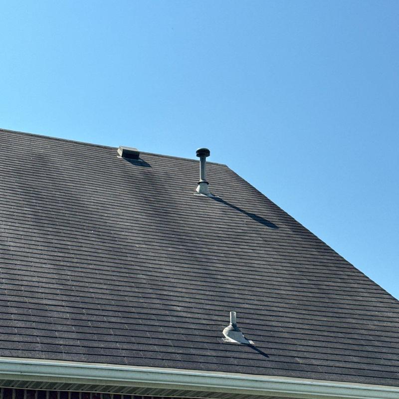 Roof shingles with hail damage under clear sky