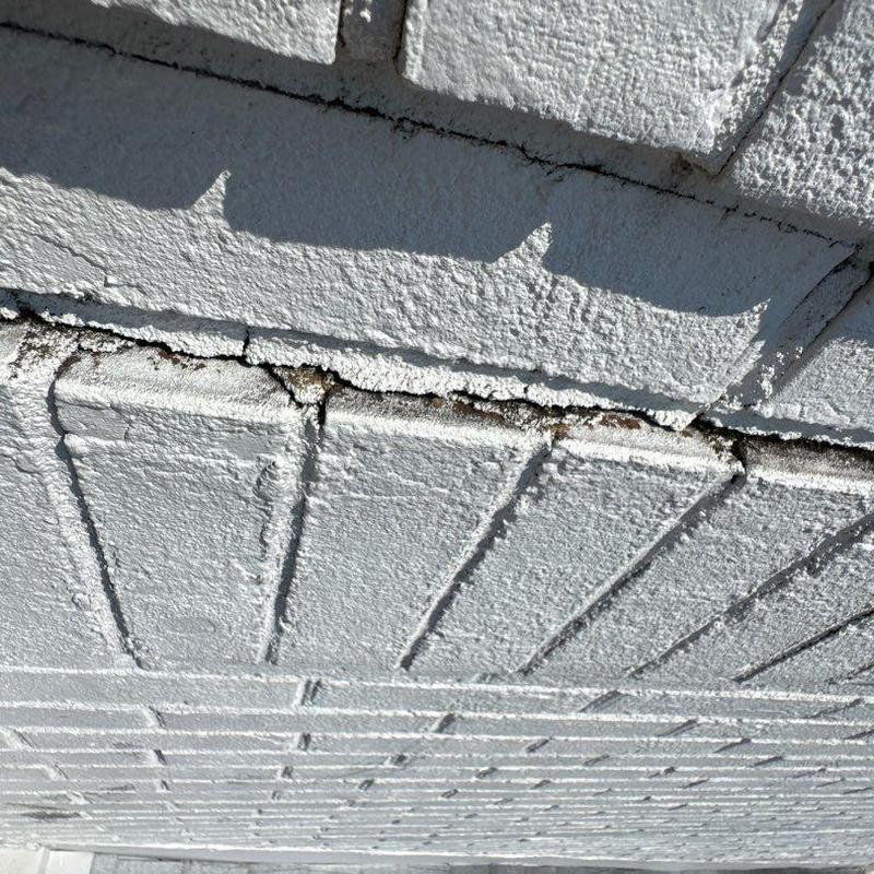 Exterior brick wall with mortar joint damage and cracks