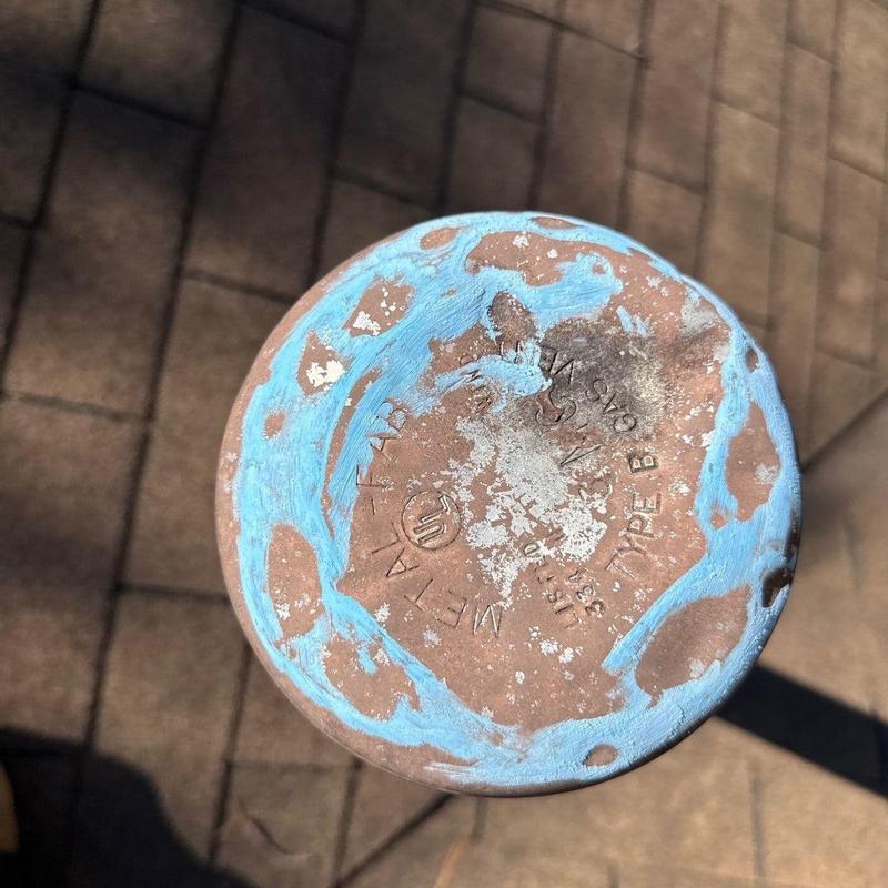Metal pipe end with worn blue protective coating