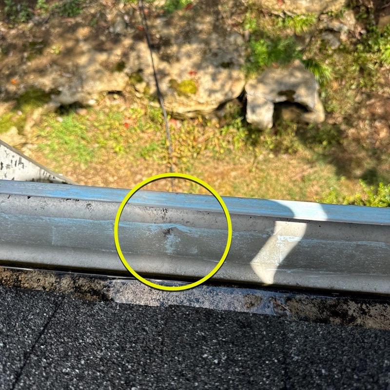 Gutter dent from hail damage on roof edge