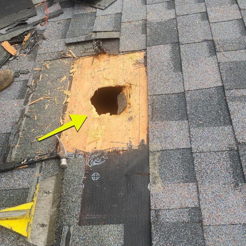 Roof plywood hole from storm damage with surrounding shingles Roof plywood hole from storm damage with surrounding shingles