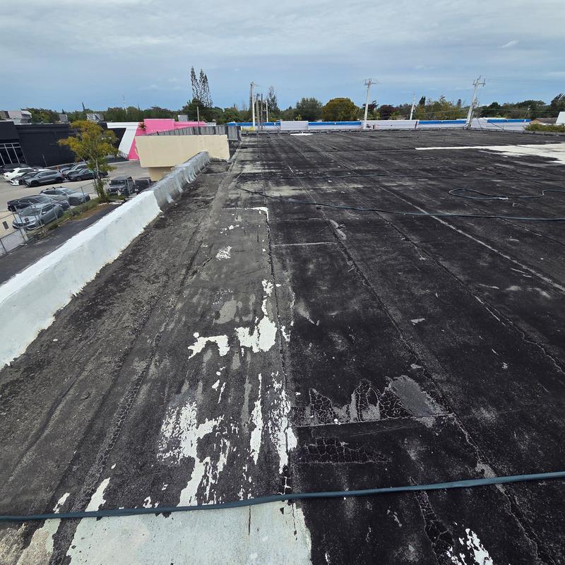 Commercial flat roof with worn membrane and patches Commercial flat roof with worn membrane and patches