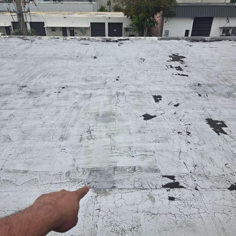 Commercial flat roof with cracking and damage areas Commercial flat roof with cracking and damage areas