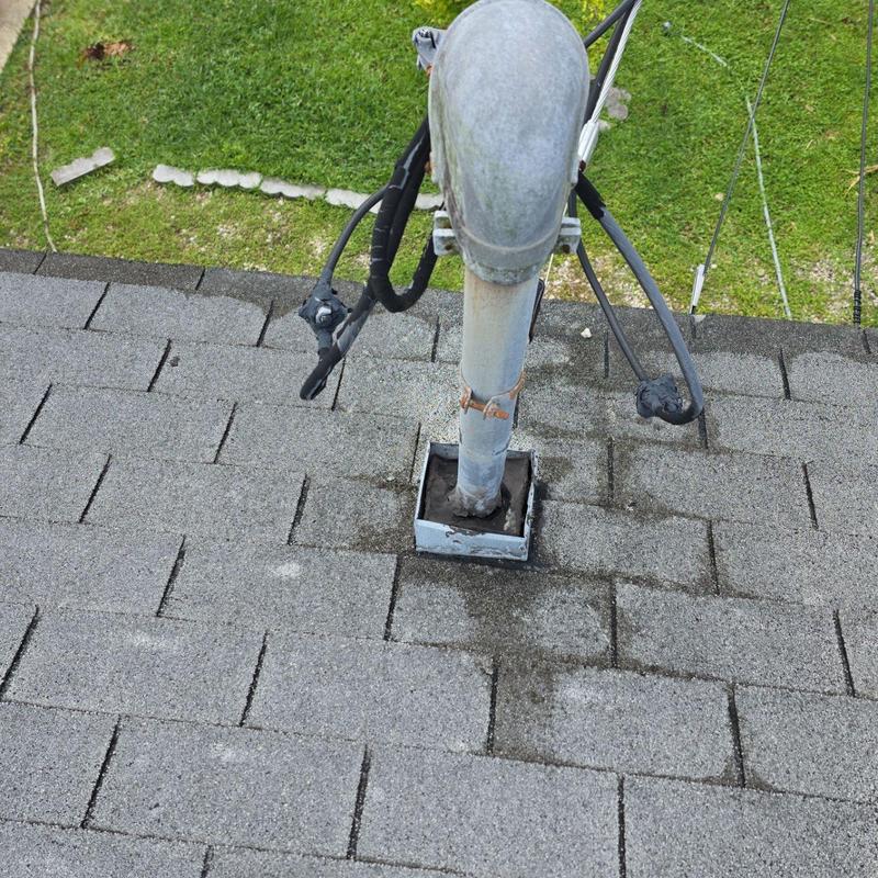 Metal vent pipe flashing on shingle roof with discoloration