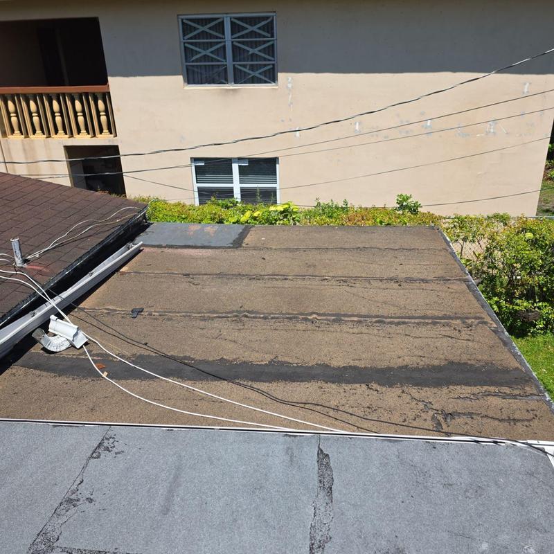 Flat roof with weathered surface and patch repairs