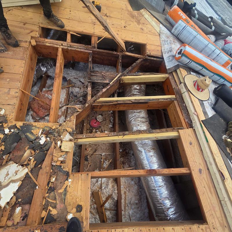 Tile roof wood framing and ductwork exposed during replacement