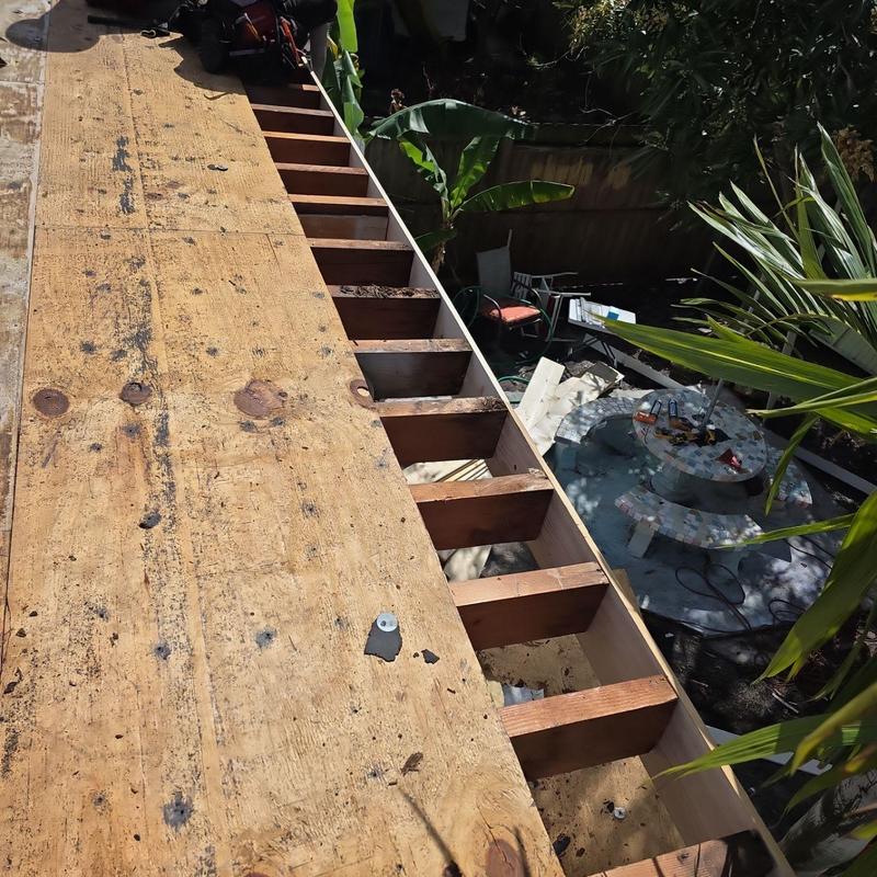 Flat roof plywood decking installation with exposed joists