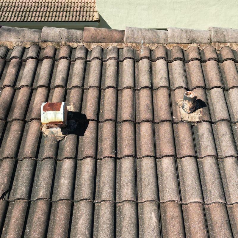 Concrete tile roof with vent pipe repairs visible