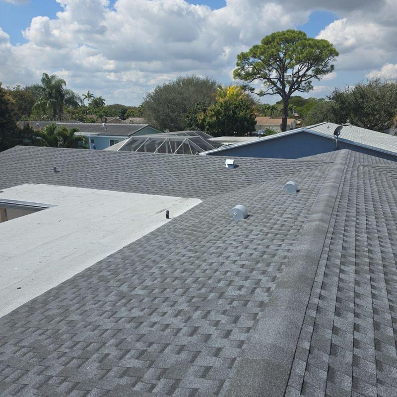 Gray shingle roof and white flat roof replacement