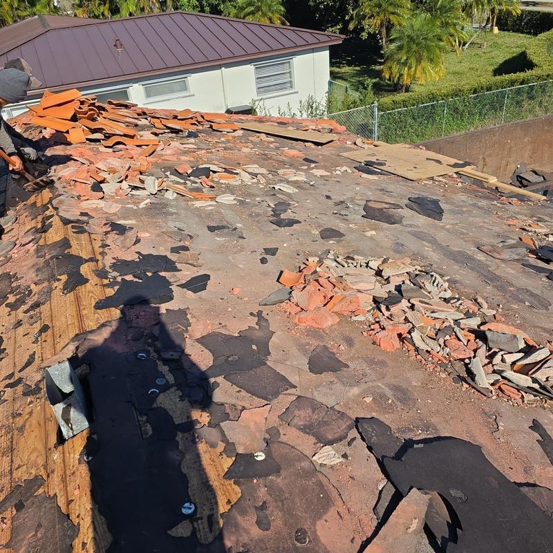 Tile roof demolition and debris removal in progress