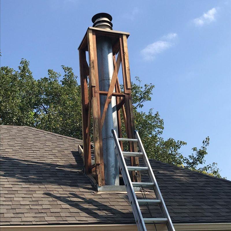 Chimney chase with wood framing and ladder on roof